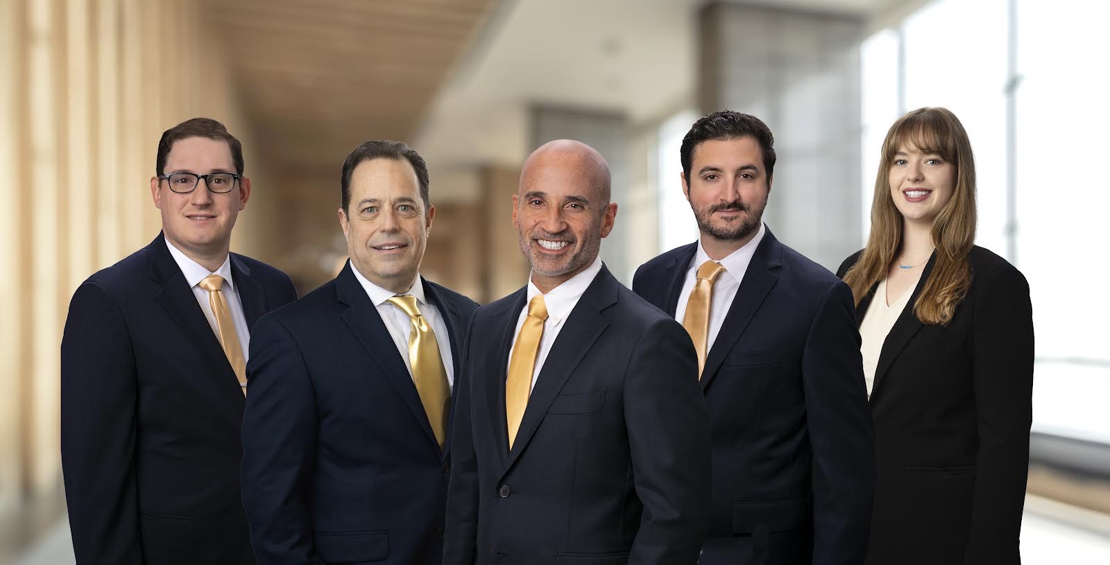 5 lawyers stand in a row in suits