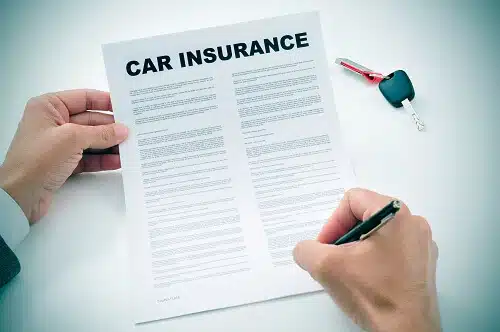 Hands holding Car Insurance paperwork
