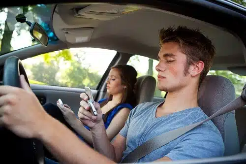 New driver is driving while distracted by his phone