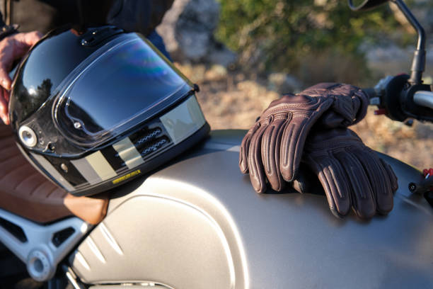 Motorcyclist gloves and helmet on a motorcycle tank